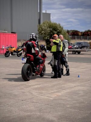 kurven.schule® Motorradfahrer erhält Tipps von zwei Instruktoren. Perfektes Training auf einem sonnigen Tag.